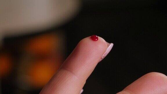 一个女人手指上的一滴血的特写糖尿病血糖仪