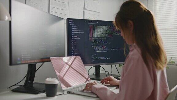 亚洲女性软件开发人员坐在办公桌前用电脑写代码