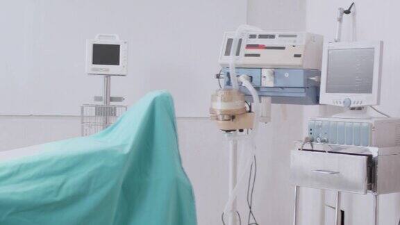 平移拍摄手术器械在无菌条件下放置于手术台上为患者在手术室进行手术做准备急救室有监视器、呼吸机和心电图仪概念医疗医院急救医疗