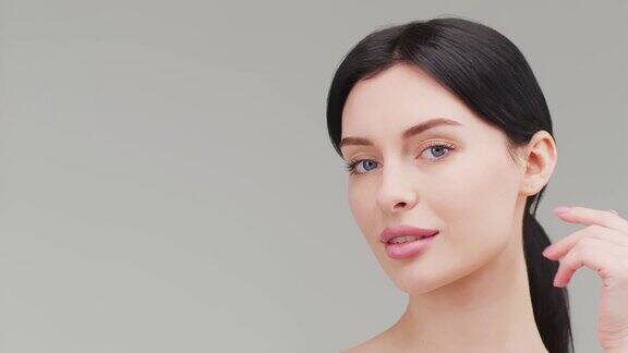 美女的脸用蓝色的眼睛看着相机孤立在白色的背景上美丽的女模特与完美的清洁新鲜的皮肤护肤治疗或化妆品广告概念