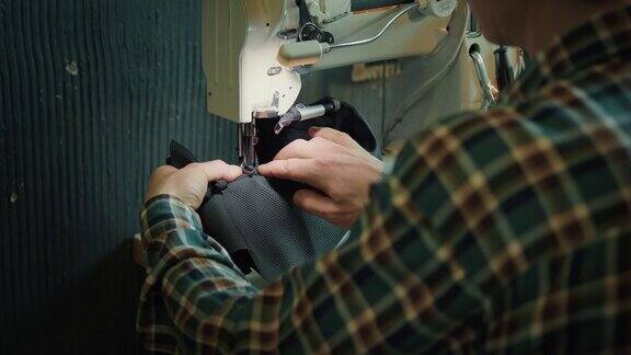 男鞋匠在私人作坊里摆弄缝纫机
