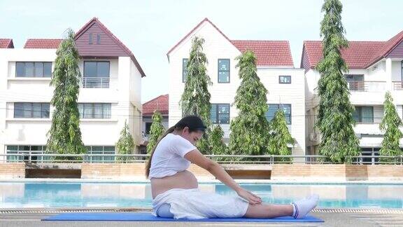 孕妇在泳池边放松做瑜伽