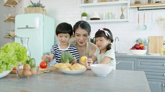 快乐的亚洲家庭在家里的厨房里做饭一起享受家庭活动