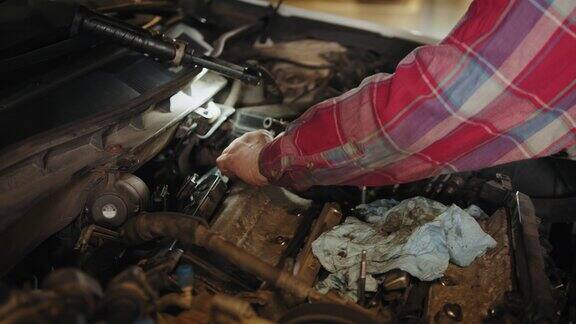 专业机械师正在汽车维修中心修理汽车修理工正在修理汽车的发动机专家用棘轮拧开螺栓汽车修理工修车