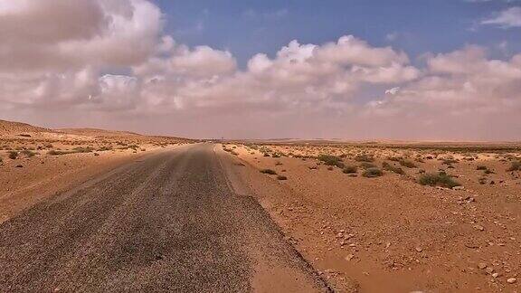 第一人称视角驾驶沿着孤独的突尼斯沙漠道路汽车司机的观点
