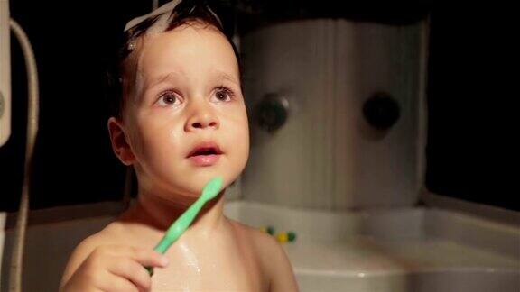有趣的小男孩2-3岁在洗澡时刷牙笑着