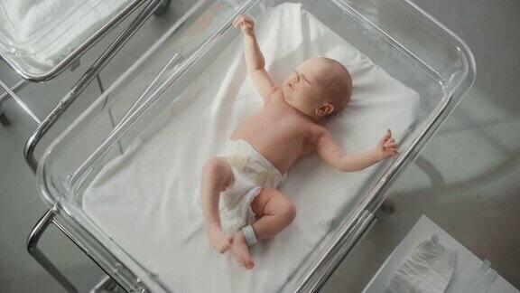 可爱的小白种人新生儿躺在医院的病床上在托儿所诊所活泼健康的小宝贝《医疗保健、产妇和父母概念》自顶向下肖像
