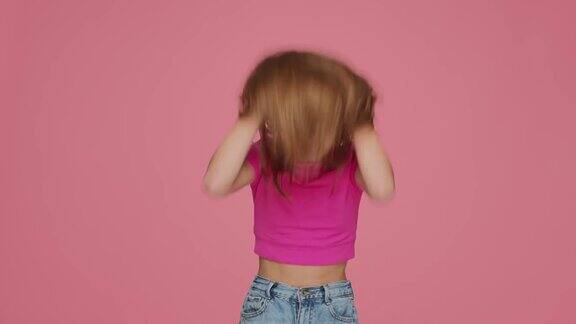 活泼有趣的小女孩摆弄着长长的金发摇着头玩得很开心儿童护发化妆品广告