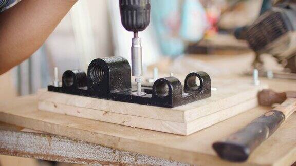 木匠用电动螺丝刀拧紧螺栓螺母