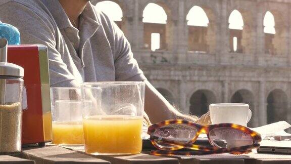 快乐的年轻游客夫妇吃早餐与咖啡牛角卡布奇诺在酒吧餐厅外面在罗马斗牛场在日落近距离拍摄