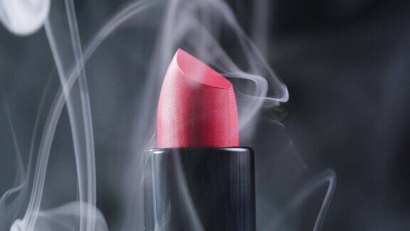 红色口红用烟雾和水滴构成特写背景不同色调的粉色青铜色口红工作室广告宏观美容理念
