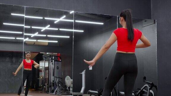 美丽的年轻亚洲女子在健身馆健身俱乐部的镜子前跳芭蕾舞锻炼有氧运动女性训练运动和热身优雅的努力饮食健康和护理