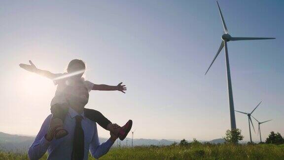 一位工程师父亲将女儿抱在怀里在风力涡轮机之间自由奔跑