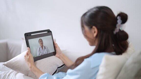 病人在家里的客厅里通过视频电话与医生交谈