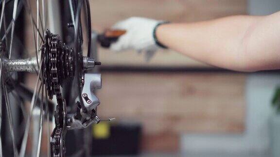 特写男自行车修理工在家车库修理自行车车轮和链条在自行车车间工作的小企业主