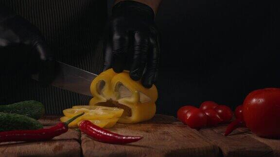 厨师用刀在木砧板上切新鲜的黄甜椒