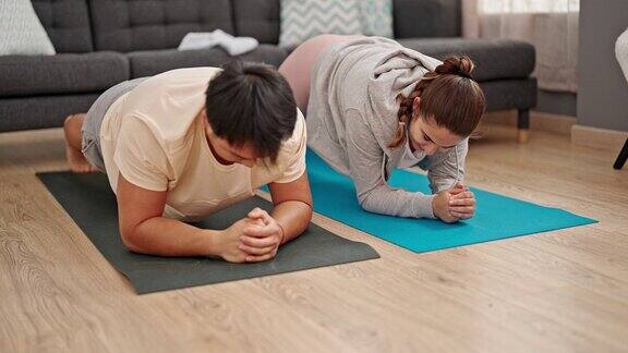 一对男女夫妇在家里做腹肌锻炼