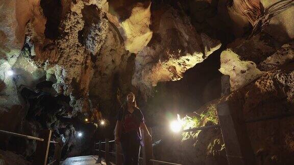 女游客在洞穴中漫步探索四处张望
