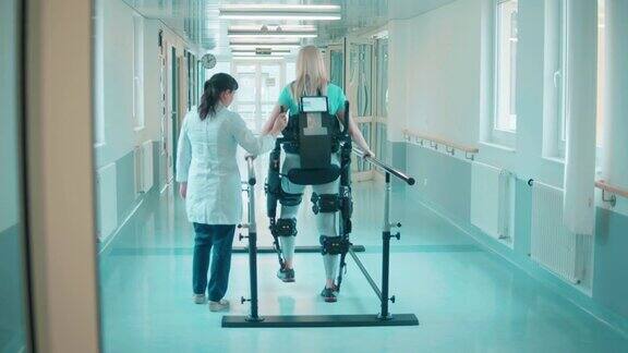 医务人员正在帮助一名妇女穿着外骨骼走路
