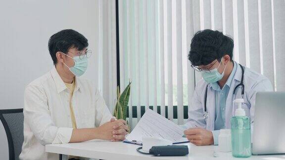 医生们正在解释在疫情期间戴口罩的患者的治疗方法