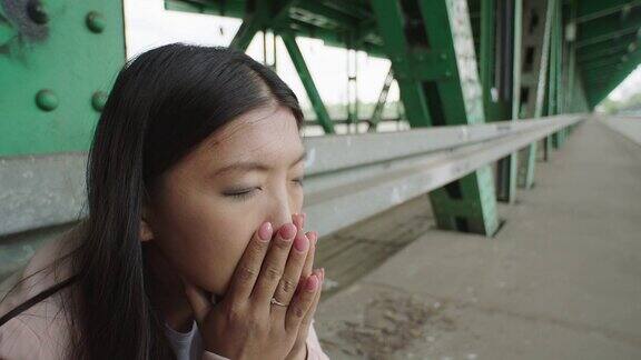 年轻女子坐在桥下孤独头的手