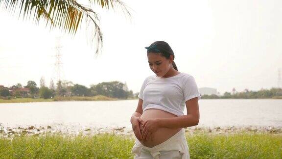孕妇在湖边放松手臂伸展