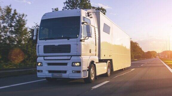 在高速公路上行驶的带有拖车的货运卡车白色卡车在清晨运送货物