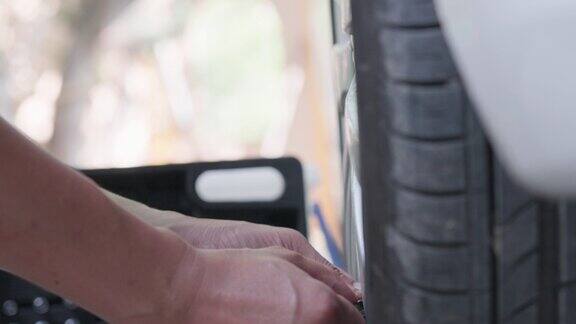 在汽车修理厂一位机械师正在检查汽车轮胎的气压驾驶观念和驾驶安全