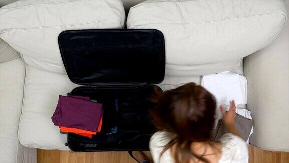 年轻女子正在精心准备夏天旅行的旅行袋