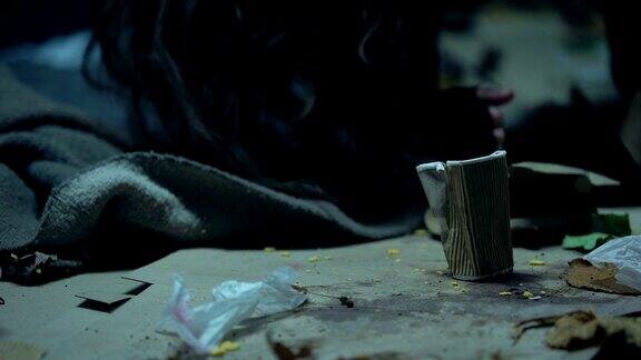 醉醺醺的无家可归的女人躺在垃圾堆里睡觉酗酒成瘾