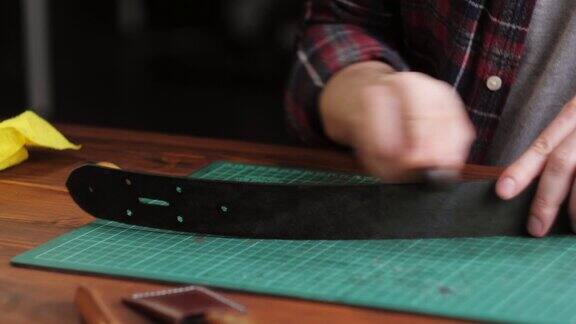 男裁缝用尺子裁剪人造革特写工匠在工作桌上雕刻牛皮制作用真皮制作的手工制品专业的工作室