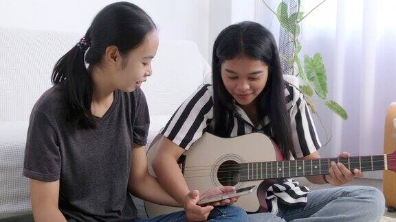 亚洲女孩在客厅弹吉他