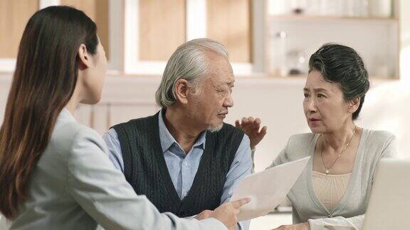 一对年长的亚洲夫妇在听售货员说话时显得很可疑