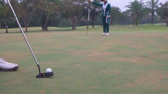 4K亚洲男子高尔夫球高尔夫球在球道上通过一个洞