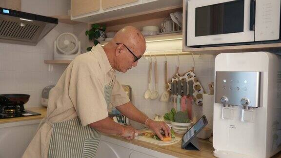 亚洲老人在厨房切菜