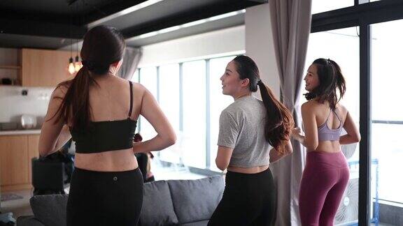 一群亚裔华人女性朋友在家里的客厅里一起锻炼