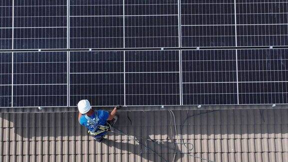 一名男性工人在调整和检查光伏太阳能板的安装