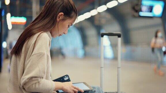 年轻漂亮的女人带着行李在机场等飞机