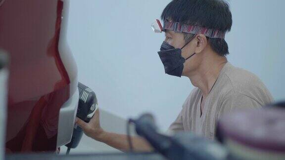 亚洲男子使用汽车抛光工具来维护汽车的漆面