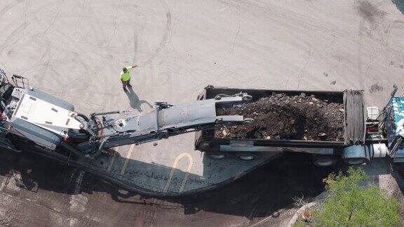 一群建筑工人在停车场和道路上撕碎旧沥青自顶向下射击