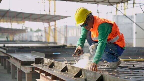 工人在工地焊接预制混凝土板的金属结构