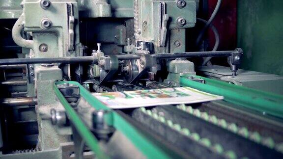 一台工业机器正在剪去印刷杂志的边缘