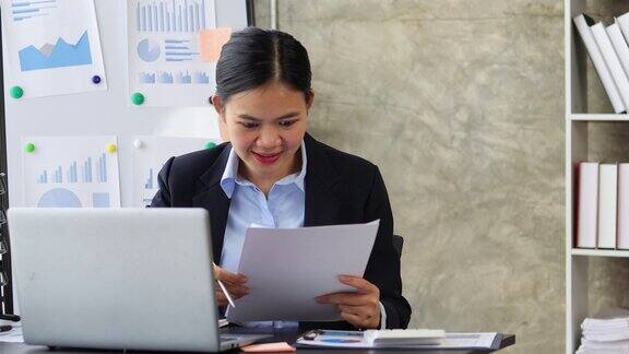 兴奋和快乐的亚洲女商人在办公室工作后成功的工作