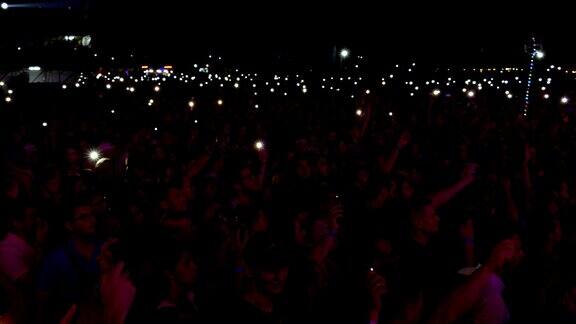 人们在摇滚音乐会上拿着手电筒