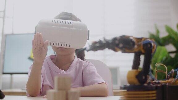 女孩在VR眼镜上控制机器人手臂在高中上机器人课