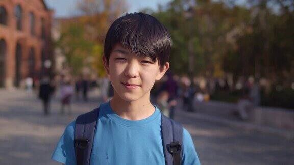 快乐的亚洲少年在户外的相机微笑实时