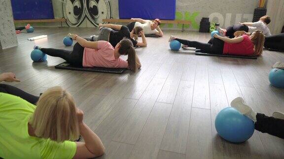 快乐的孕妇在健身房的垫子上锻炼