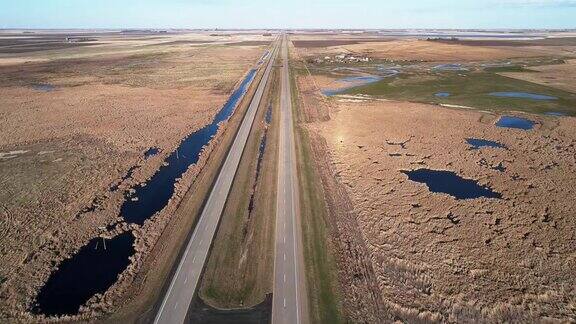 北达科他州的2号高速公路在春天的田野里无人机视频与向后相机运动