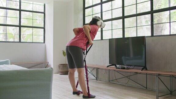 戴着人工现实眼镜的年轻运动女性在家锻炼