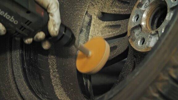 轮胎蒙太奇清洁轮辋电刷汽车轮服务工作车库车间在汽车修理店工作特写镜头